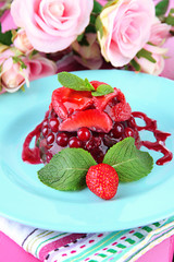 Tasty jelly dessert with fresh berries, on pink roses