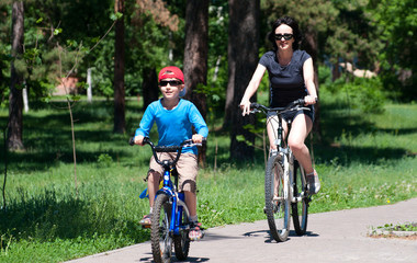 Mother and son riding bikes outdoors in summer