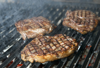 beef steak cooking on an open flame grill