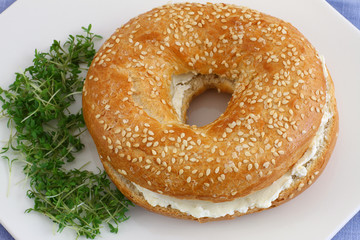 Bagel with cream cheese with watercress garnish