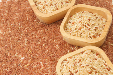 wheat kernel in the wooden bowl on brown rice background