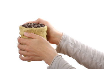 Small bag of coffee beans in female hands, isolated on white