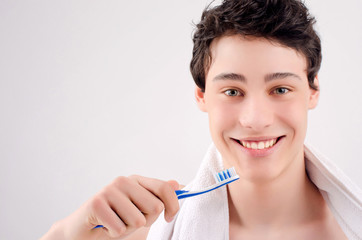 Man with beautiful teeth smiling and holding a toothbrush.