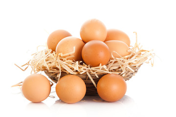 Brown eggs in the basket on white.