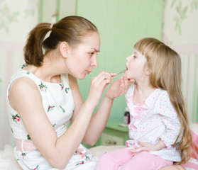 Obraz na płótnie Canvas mother examining little girl's throat