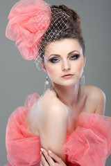 portrait of beautiful girl with a hat from a pink veil