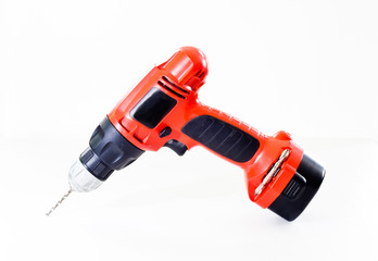 Hand holding battery drill and drills wooden board, isolate