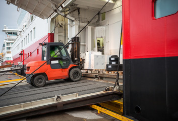 Lift truck unloads big passenger ship through opened side ramp © evannovostro