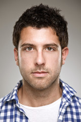 Portrait of a normal young man on a grey background