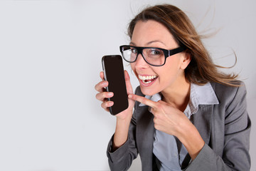 Business girl with funny look showing smartphone