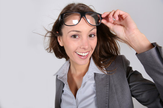 Funny businesswoman lifting eyeglasses up