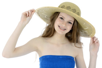 Freundlicher Teenager in Sommerkleid trägt Strohhut