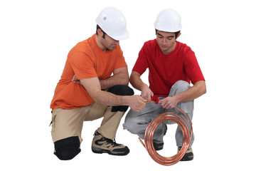 Two plumbers with copper pipe