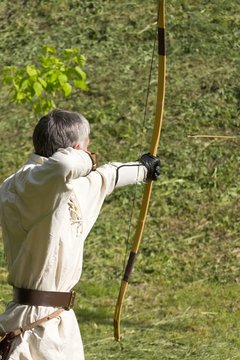 man shoots and classic bow
