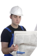 Junger Bauarbeiter liest Zeitung / Stellenangebote