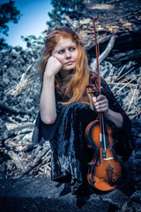 Obraz premium The red-haired girl with a violin outdoor