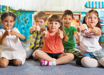 Five little children with thumbs up