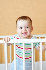 smiling baby boy in white bed