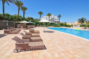 Summer day in the pool with sunbeds and parasols. Portugal Algar