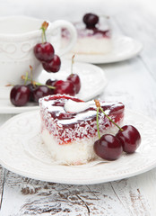 Sweet cakes with cherries on white wooden table