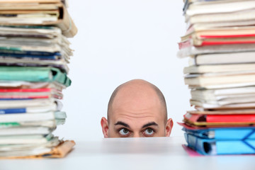 Man peeking through stacks of folders