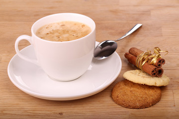 Cup of cappuccino with cookies and cinnamon