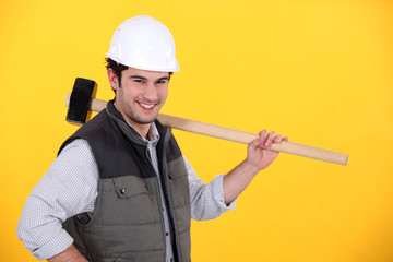 Happy builder carrying sledge-hammer