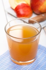 Glass of apple juice on blue napkin