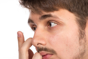 Obraz premium Closeup view of a man's brown eye while inserting a corrective c