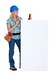 Female electrician with blank poster