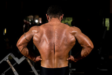 Fototapeta na wymiar muscular bodybuilder showing back lat spread
