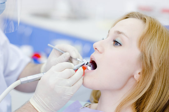 girl during drilling treatment at the dental clinic