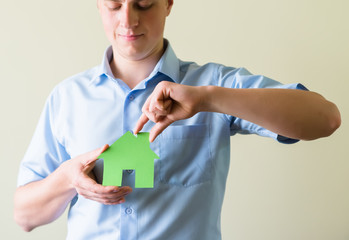 young man holding a paper house in hands