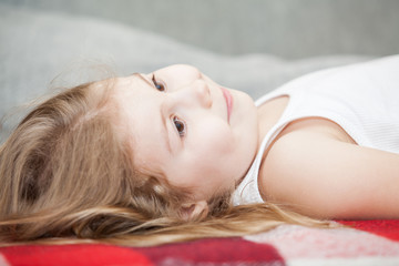 Obraz premium Little Caucasian Child lying on his back on the sofa. Close up