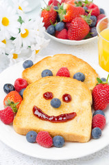 Breakfast with a smiling toast, fresh berries and orange juice