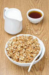 homemade muesli, jug of milk and a bowl of honey for breakfast