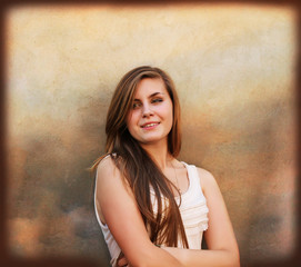 Fototapeta premium Beautiful girl smiling on background of vintage wall
