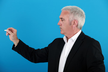 A businessman holding a chalk.