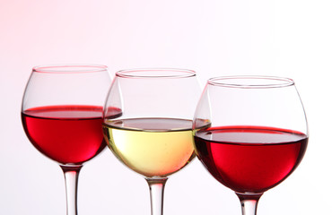 Glasses of wine on light pink tone