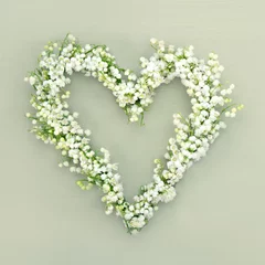 Foto auf Acrylglas Maiglöckchen Heart shaped flower wreath on green background