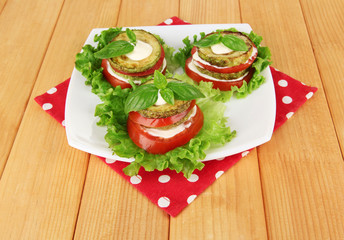 Tasty roasted marrow and tomato slices with salad leaves,