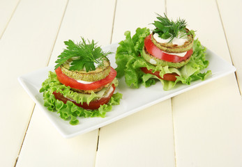 Tasty roasted marrow and tomato slices with salad leaves,