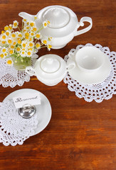 Table setting with chamomiles on wooden table