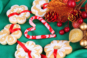 Christmas cookies and decorations on color fabric background