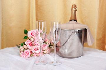 Champagne and glasses on round table on cloth background