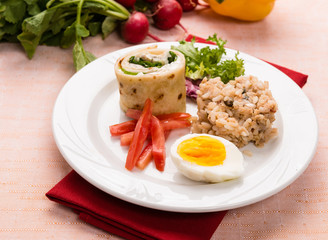 Piatto con piadina, uovo, riso e verdure