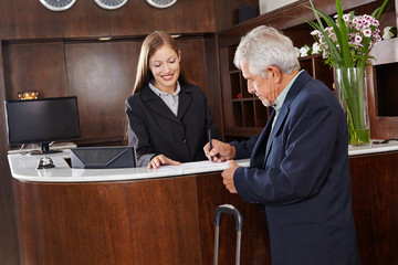Gast unterschreibt Formular im Hotel