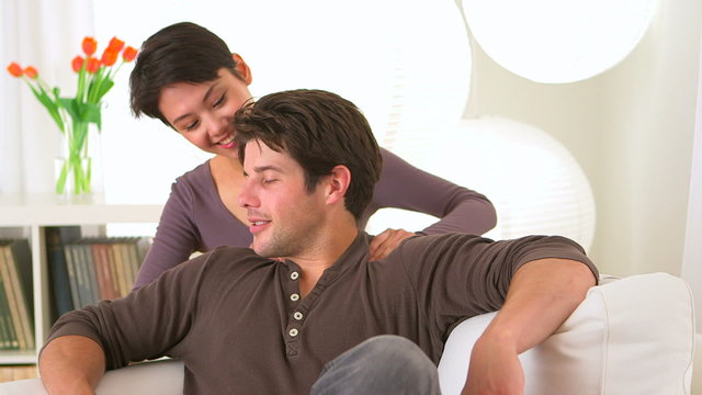 Chinese woman giving boyfriend a massage