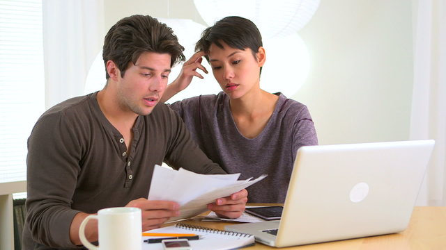 Mixed race couple looking over finances