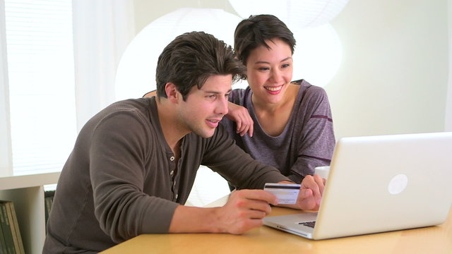Chinese woman excitedly shopping online with boyfriend